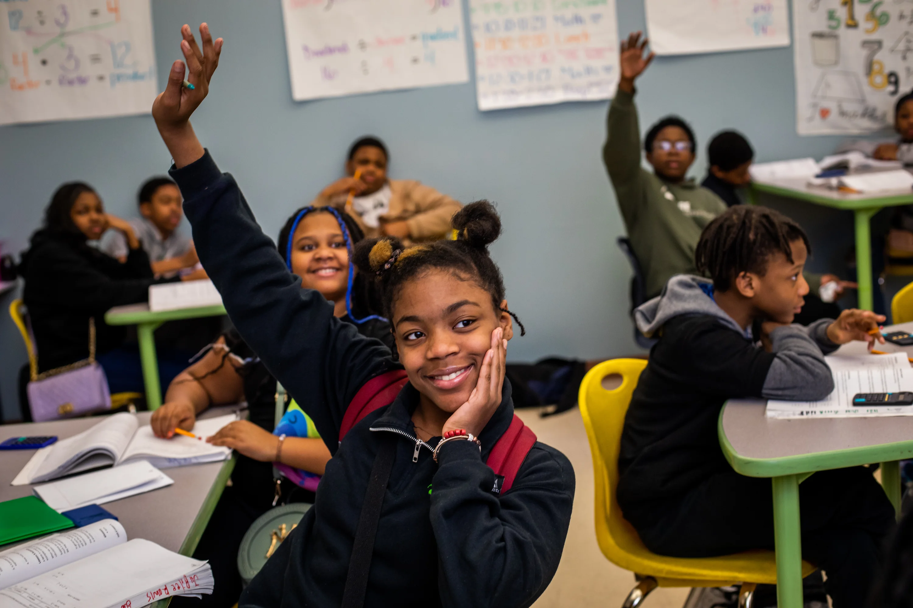 Freire Middle students raising hands in class