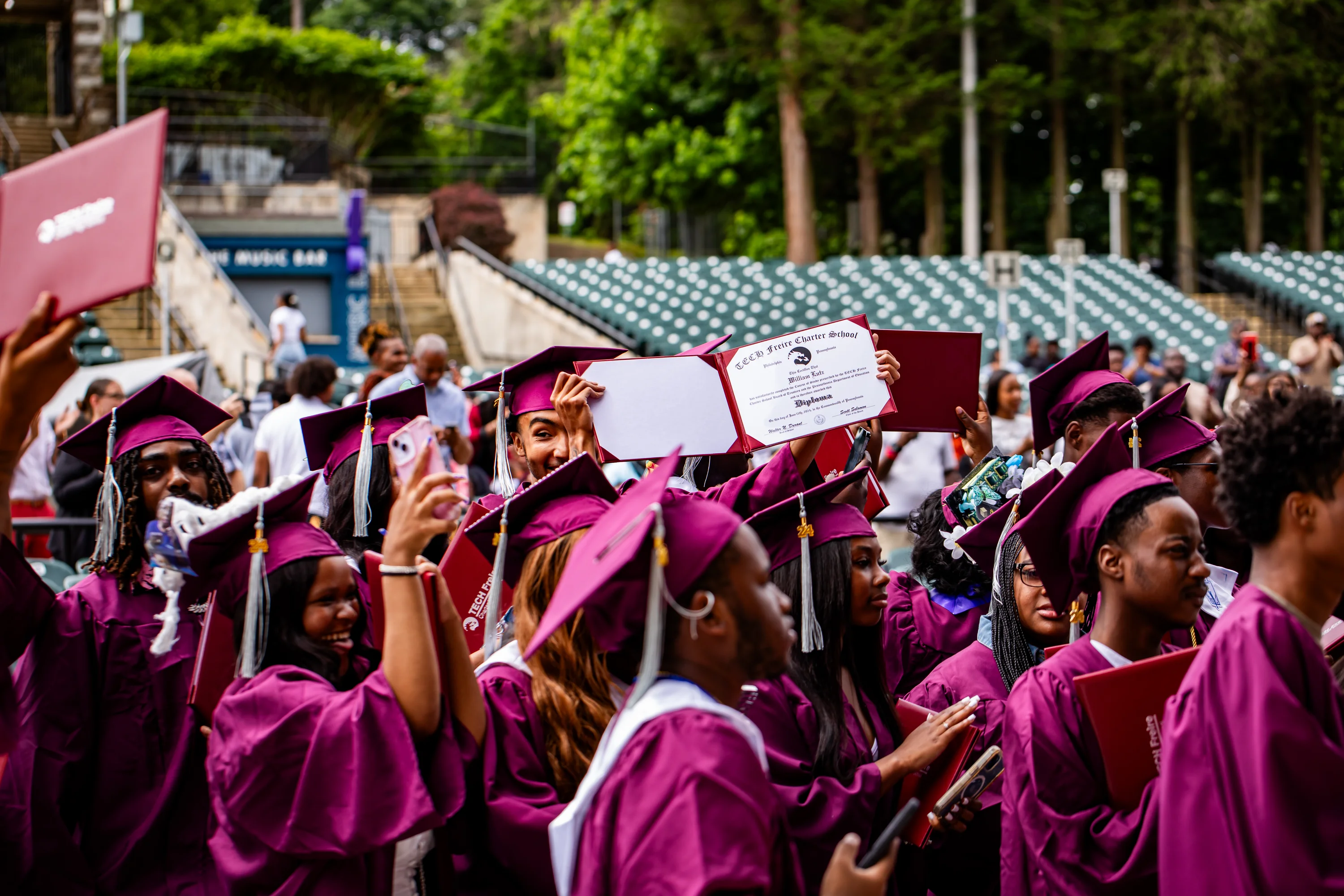 Freire graduates celebrating with their diplomas