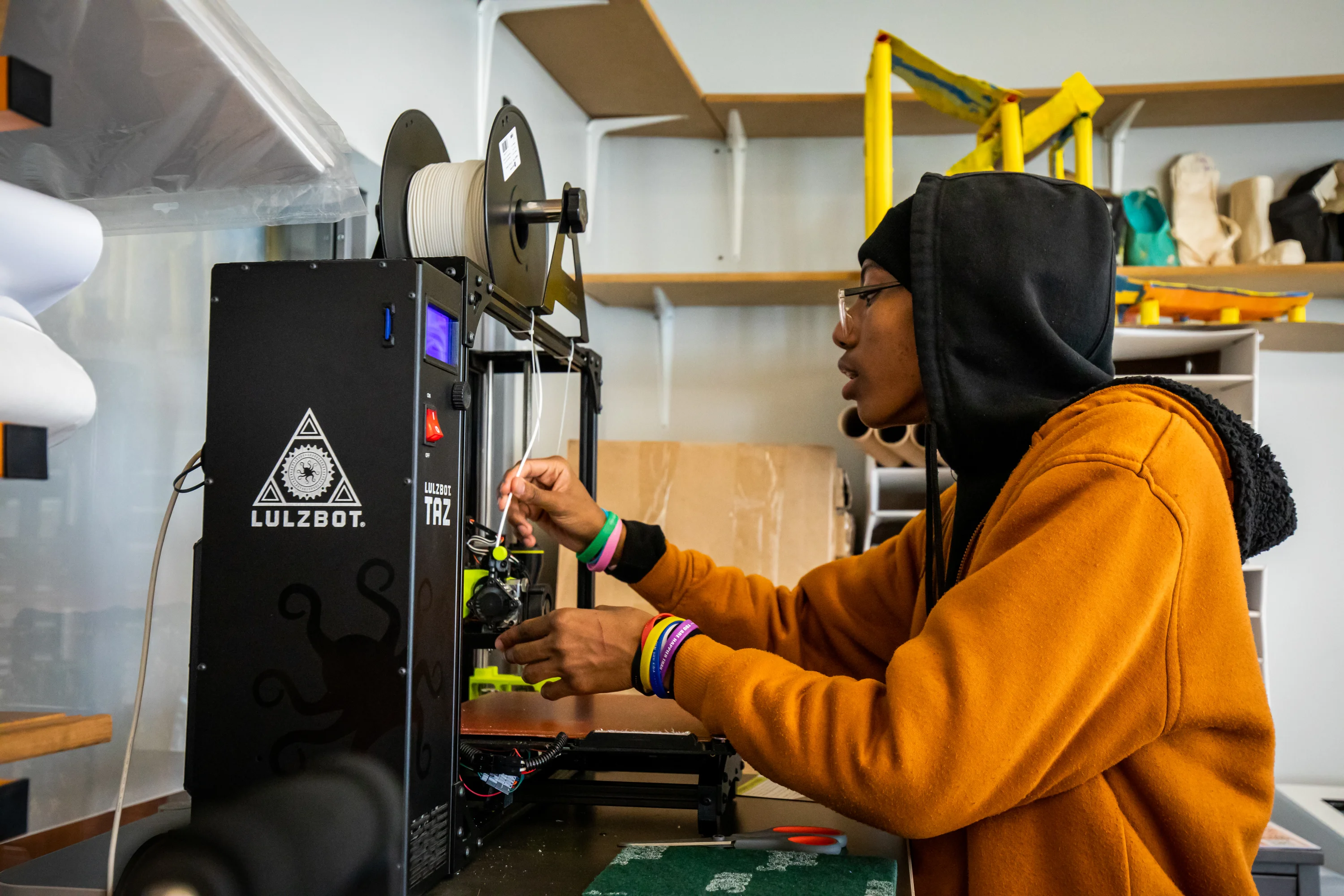 TECH Freire student working with a 3D printer in the makerspace